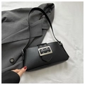 Detailed close-up of a black matte leather underarm bag with a bold silver metal buckle - Black
