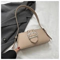 Close-up of beige leather underarm bag featuring a large silver buckle and wide strap - Khaki