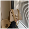 Détail du sac trapèze beige clair avec fermoirs hexagonaux dorés et bandoulière chaîne - Kaki