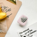 Gros plan du support de téléphone cœur à damier rose sur un fond blanc texturé - Rose