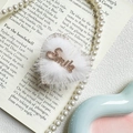 Dettaglio di un accessorio Smile in peluche a forma di cuore con perle e libro - Bordo Dorato a Forma di Cuore