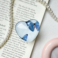 Detailed view of a heart-shaped resin phone stand with deep blue butterfly patterns - White Base / Hand-painted Butterfly