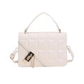 Close-up of beige quilted handbag featuring luxury gold-black lock and chain strap - White