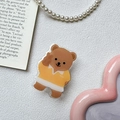 Detalle de un soporte para móvil de oso pardo con camisa amarilla sobre fondo blanco rugoso - Transparente-Oso Camiseta Amarilla Signo V