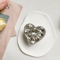 Dettaglio del supporto per telefono a cuore con strass scintillanti su vassoio - Bianco