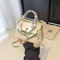 Elegante beige Handtasche mit Krokodilmuster, Seidentuch-Griff und goldenem Drehverschluss - Mit Anhänger-Schal / Cremeweiß / [produktmerkmale] Es Handelt Sich Anscheinend Um Eine Hellbeige Handtasche Mit Krokodilmuster In Klassischer Trapezform. Sie Verfügt Über Einen Mit Einem Bedruckten Seidentuch Umwickelten Tragegriff Und Einen Verstellbaren Schulterriemen. Ein Goldplattierter Druckknopfverschluss An Der Vorderseite Unterstreicht Den Eleganten Französischen Stil. [visuelle Präsentation] Das Bild Zeigt Eine Person Mit Der Tasche Vor Einem Hintergrund Aus Weißen Plisseevorhängen Und Einer Schlichten Schwarzen Wand. Rechts Ist Ein Kunstbuch Mit Dem Titel „café De Flore“ Als Requisite Platziert Wodurch Ein Sanfter Lichteffekt Entsteht. Die Bildqualität Ist Hoch Und Die Auflösung Gut. Die Ästhetische Wirkung Ist Mit Einer Gesamtbewertung Von 85 Sehr Gut. Requisite Und Produktstil Sind Stimmig. [textinhalt] Das Bild Enthält Lediglich Publikationsinformationen Aus Dem Requisitenbuch (café De Flore Usw.) Die Als „prop_text“ Gekennzeichnet Sind Und Keiner Weiteren Bearbeitung Bedürfen. [logistik-label] Risiko Von Urheberrechtsverletzungen. [risiko Einer Rechtsverletzung] Produktrechtsverletzung: Hermès – Klassische Tasche (kelly-modell) Wahrscheinlichkeit [07] Aufgrund Der Hohen Ähnlichkeit Zwischen Der Form Und Dem Verschlussdesign Der Tasche Und Der Hermès Kelly-serie. Hintergrundrechtsverletzung: Keine. 【produktparameter】hellbeige Krokodilprägung Goldfarbene Beschläge Seidentuch-verzierung.