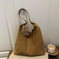 Sac à main en daim marron avec pendentif chien en peluche sur une couverture beige - Style pendentif / Kaki