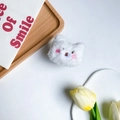 Primer plano del soporte de móvil de oso de peluche blanco en una bandeja de madera - Oso de Mejillas Rosadas / Blanco