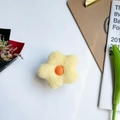 Dettaglio macro del supporto per telefono a fiore giallo morbido su sfondo bianco - Fiore in Peluche Giallo