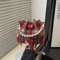 Bolso cubo de tweed rojo con asa de perlas y correa al hombro en un ambiente elegante - Rojo