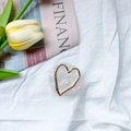 Detalle del soporte móvil de mármol con marco de corazón dorado sobre tela blanca suave - Base Transparente - Corazón Hueco Dorado - Redondo Blanco Perla