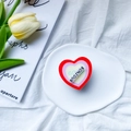 Rotating heart-shaped phone grip with Bonjour text on a stylish decorative tray - Red Heart (BONJOUR)