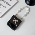 Detail of Galaxy Z Flip case with pearl handle strap and sparkling metal bow ornament - Pearl Bow with Pearl Chain (Black) / Black / Samsung ZFlip3