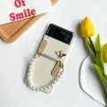 Detail of Galaxy Z Flip phone case featuring a gold bee ornament and pearl handle strap - Small Pearl Bee (Z Flip 5)