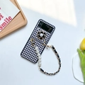 Detalle de funda Galaxy Z Flip con diseño de pata de gallo, camelia y cadena de perlas - Negro / Samsung ZFlip5
