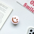 Detailed view of pink phone socket with brown smiley face on white marble background - Pink