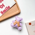 Detail of a purple leather bear phone socket with a brown bow on a wooden tray - Purple