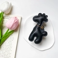 Macro detail of giraffe phone socket in black lychee leather with gold chain decoration - Black