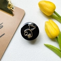 Top view of a glossy black phone grip with a gold metal bear design near yellow tulips - Black Base - Round Hollow Tilted Head Bear