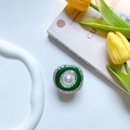 Vista macro di un supporto per telefono retrò con perla bianca e smalto verde - Stile Palazzo Argentato Metallico
