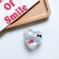 Clear heart phone socket with red bow and silver glitter inside on a wooden tray - Heart Pattern Bow