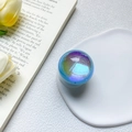 Close-up of holographic glitter resin phone socket on a tray with floral background - Light Blue
