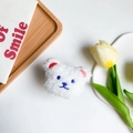 Dettaglio di un supporto per telefono a forma di orsetto di peluche bianco con ricami - Bianco