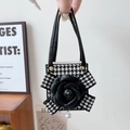 Detail of houndstooth Z Flip case featuring a black camellia flower and pearl charm - Black / Samsung ZFlip3