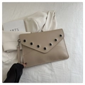 Close-up of beige rivet clutch bag with V-shaped flap and black metal eyelets detail - Dark Khaki