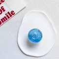 Blue translucent round donut phone socket with colorful sequins on ceramic tray - Jelly Blue