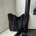 Minimalist large black tote bag with silver studs and matte finish in a modern scene - Black