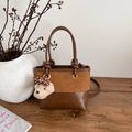 Vintage brown bucket bag with teddy bear charm on a rustic wooden table setting - With Pendant / Brown