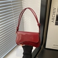 Glossy red patent leather underarm bag with elegant knot details on shoulder strap - Red