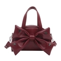 Burgundy bucket bag with bow detail and star studs, featuring a handle and chain strap - Red