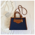 Dettaglio della borsa tote in denim blu e pelle marrone con cuciture a contrasto - Blu scuro
