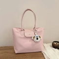 Rosa Nylon-Tragetasche mit Ledergriffen und niedlichem Welpen-Anhänger auf Holztisch - Mit Anhänger / Rosa
