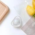 Détail d'un support de téléphone iridescent avec cadre nacré sur un bureau blanc épuré - Style Carré