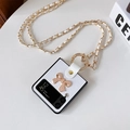 Détail de la coque blanche avec nœud en perle et chaîne en or pour téléphone pliable - Blanc / Samsung ZFlip5