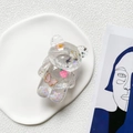 Dettaglio di un supporto per telefono a forma di orso con glitter, stelle e fiori colorati - Farfalla Rosa