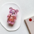 Dettaglio del supporto per telefono orsetto glitter rosa con fiore d'oro e perle - Rosa