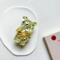 Dettaglio del supporto per telefono a forma di orso glitterato con fiore e perla - Giallo