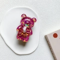 Dettaglio macro dell'orso glitter viola porta cellulare con perla e fiocchetto - Rosa Rosso