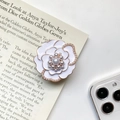 Dettaglio del supporto per telefono a fiori con perle metalliche su smartphone bianco - Bianco
