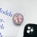 Dettaglio del supporto per telefono con strass e fiocco rosa su carta bianca - Rosa (Supporto Diamante-Fiocco di Perle)