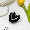 Detailed view of a glossy black heart hair clip with gold metal rim and retro chic style - Black Base - Hollow Heart - Black Heart