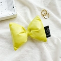 Détail d'un support de téléphone nœud jaune 3D gonflé avec étiquette tissée noire sur coton - Jaune