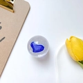 Macro shot of a crystal phone grip with a blue heart inside on a minimalist white desk - Royal Blue