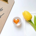Detail view of a clear resin phone grip with an orange 3D heart and tulip backdrop - Orange