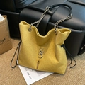 Glittery yellow tote bag with chain strap and metal logo on a cozy background - Yellow
