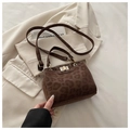 Detalle del bolso cuadrado con estampado de leopardo y cierre dorado sobre tela beige - café